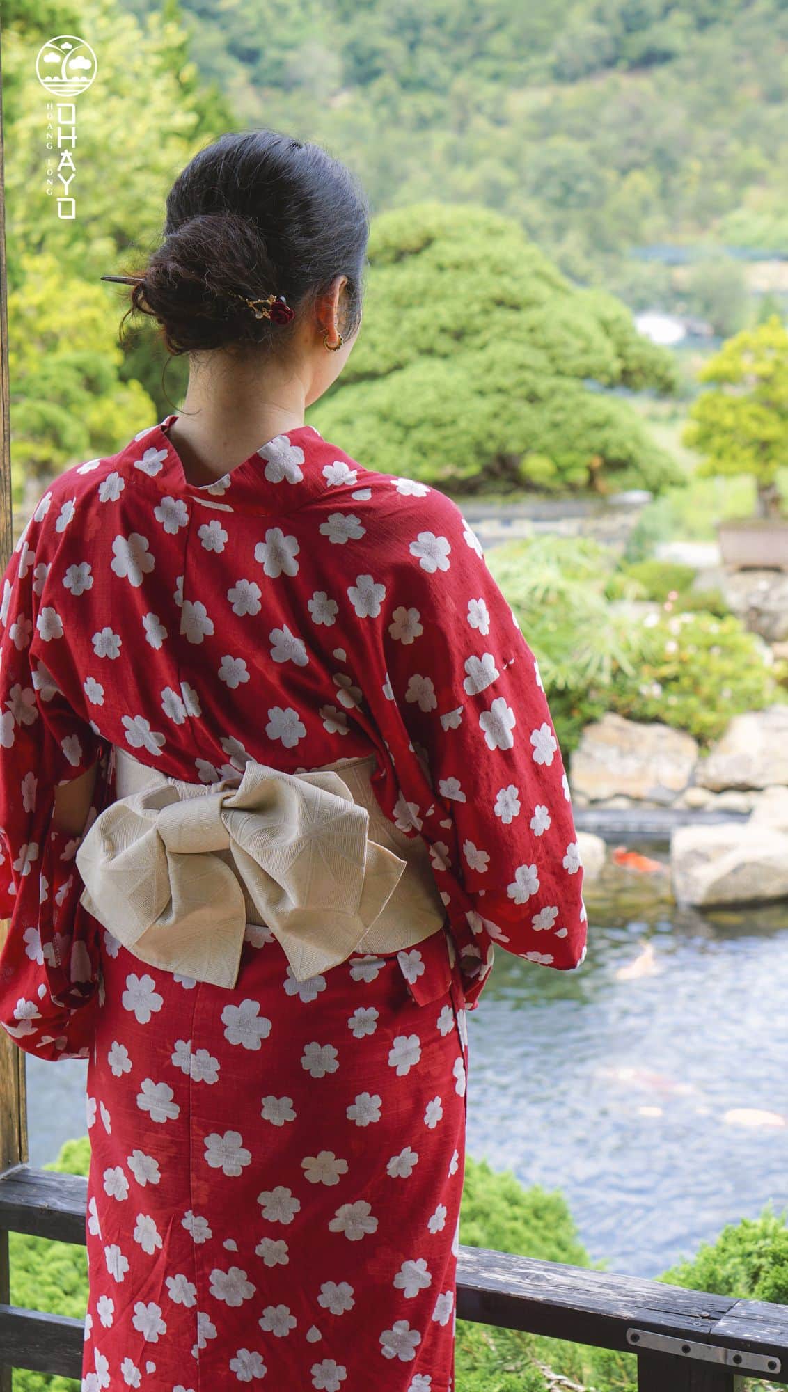 Khách mặc yukata đỏ nhìn xuống vườn